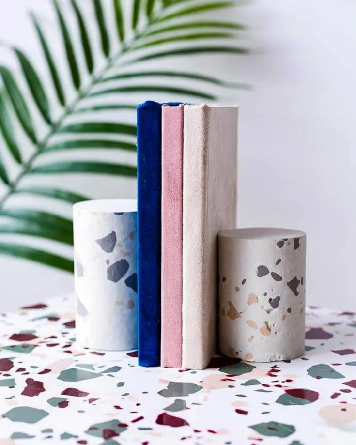 Terrazzo is a type of composite material that has pieces of marble, glass, and other decorative materials in it. Why not make a bookend out of it? It gives such a premium look to your shelves!