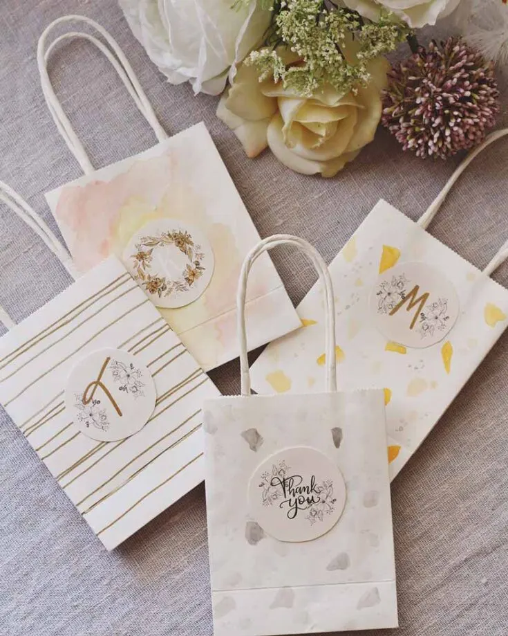 Here are some simple goodie bag ideas for wedding guests! Decorate paper bags with watercolor designs and labels featuring the bride and groom's initials, a charming floral motif, or a heartfelt "Thank You" message.