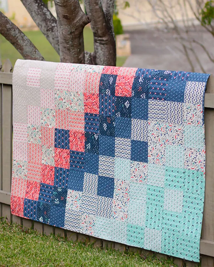 Look at the stunning color gradient of this Wildwood crib quilt from Bonjour Quilts! With the contrasting color patches running parallel from each other and the use of scrappy binding to give off a seamless edge to this quilt, we would have thought of this as a work of art.