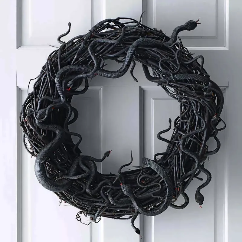 Hiss... Get ready to welcome guests with a twist of fun with this wriggling snake wreath! Isn't it cool? They're easy to make, and they remind us of Medusa. So, if you plan on dressing up as her, try this out!